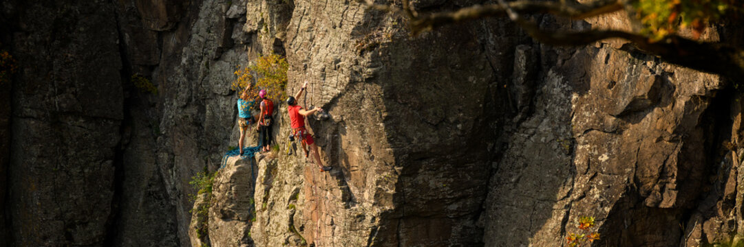 Rock climbers. Active lifestyle, risky hobbies, dangerous adrenaline sports background. Group of friends climbing Hradok rock wall in Slovakia.