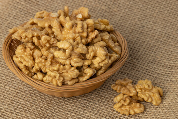Basket with peeled walnuts on burlap.