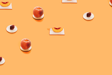 Pattern made of fresh peach fruit, slice and peach pit on stand on bright orange background. Minimal health and organic concept. Creative fruit layout. Eating healthy idea with copy space.