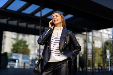 Attractive business woman talking on mobile phone with client.