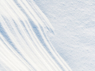 Obraz premium Beautiful winter background with snowy ground. Natural snow texture. Wind sculpted patterns on snow surface.