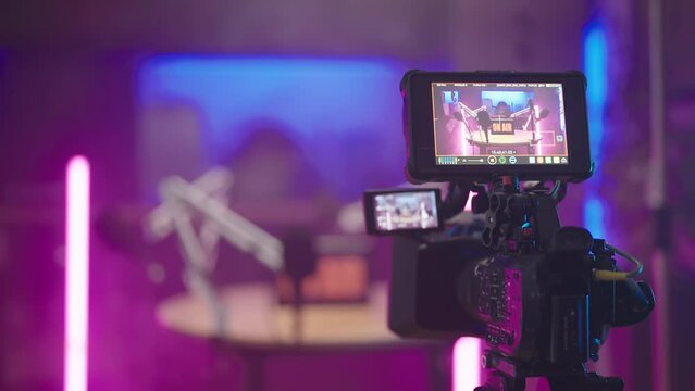 Behind the camera of podcast recording in kitchen with pink neon tubes 4K