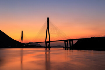 朝焼けに染まる海と橋