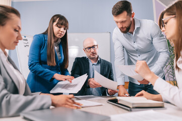 A team of business people are discussing the project together in the office.