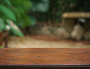 empty top table of brown wood texture in tropical garden fresh green plant blurred background with copy space.for organic healthy natural product present promotion display,nature forest design.
