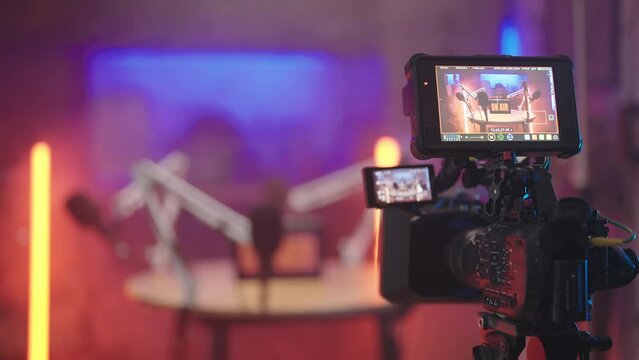 Professional camera recording podcast studio broadcasting in kitchen with red neon tubes 4K