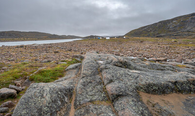 A distant group of camping tents beside the Sylvia Grinnell River in Sylvia Grinnell Territorial Park, Nunavut, Canada 