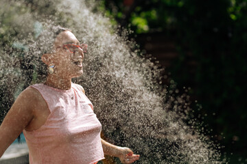 Beautiful young woman having fun in summer garden with garden hose splashing rain. soft backlight, motion - 538898860