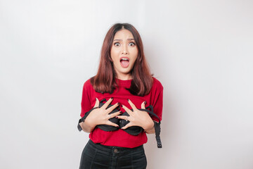 A woman is shocked while holding a bra against a white background. Concept of Breast cancer...