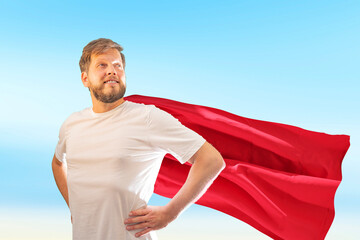 A male superhero is wearing a red superhero cape