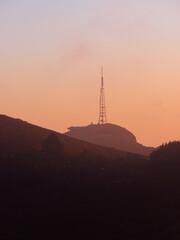 A tall transceiver tower in the hill.