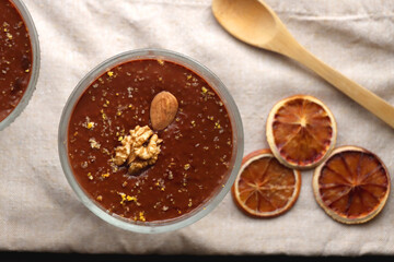 Bowl of homemade chocolate chia pudding, made with dark chocolate, chia seeds, orange juice and plant based milk. Top view.