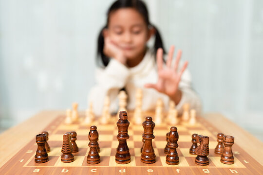 Blurred of unidentified girl is feeling give up for the chess board game. Concept of kid education, flexibility, effort, lose and win in competition.
