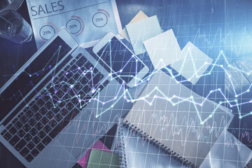 Financial market graph and top view computer on the desktop background. Multi exposure. Investment concept.