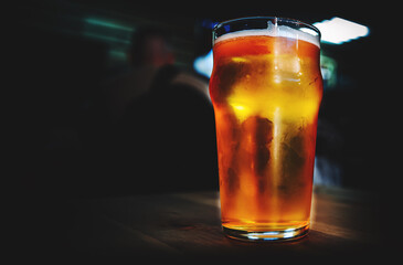 glass of light beer stand on bar counter in a bar or pub