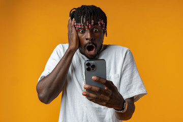 Young african man using smartphone over isolated yellow background
