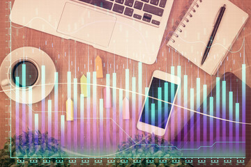 Double exposure of financial chart hologram over desktop with phone. Top view. Mobile trade platform concept.
