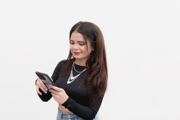 Naklejka premium A young lady surfs the internet using her phone to check her social media accounts. Studio shot isolated on a white background.
