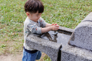 水道で手を洗う子供