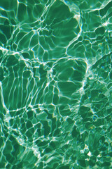 Defocus blurred transparent green colored clear calm water surface texture with splash, bubble. Shining green water ripple background. Surface of water in swimming pool. Green bubble water shining.