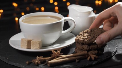 Female hand dipping cookies in milk