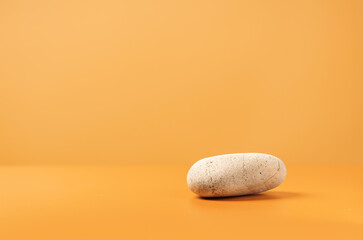 Mockup scene with stone on a yellow background. Natural pedestal for cosmetic product presentation or package advertisement. Stage for advertising. Copy space.
