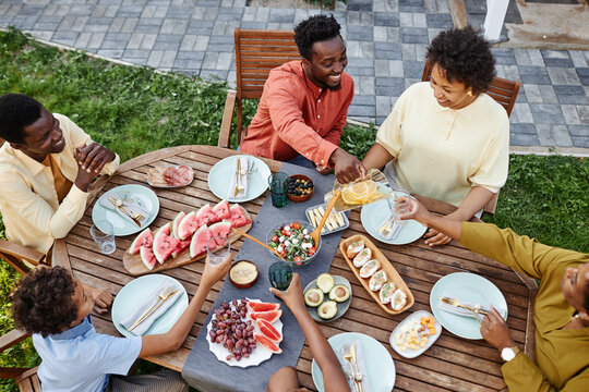 Top view at happy black family enjoying dinner outdoors during Summer party or family gathering