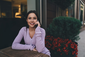 Smiling woman talking on smartphone in cafe