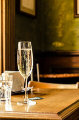Sparkling wine in a glass with bubbles on the background of a vintage house.