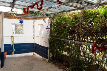 Jewish festival of Sukkot in Israel. Traditional sukkah with handmade decorations near the building on the street. 