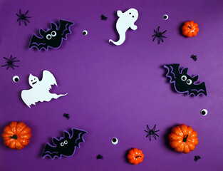 Obraz na płótnie Canvas Halloween composition with ghosts, bats, spiders and pumpkins on purple background.