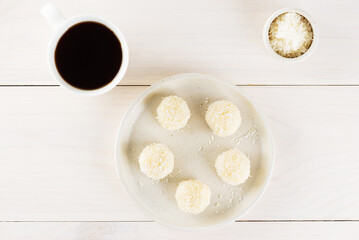 Coconut bejinho brigadeiro, a traditional Brazilian truffle on a table, flat lay, top view.