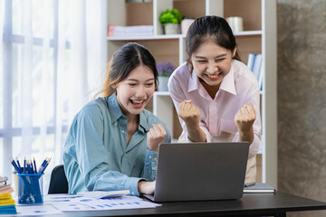 Two young Asian women discuss the concept of a new start-up project. analysis of financial planning and statistics and investment market on laptop computers