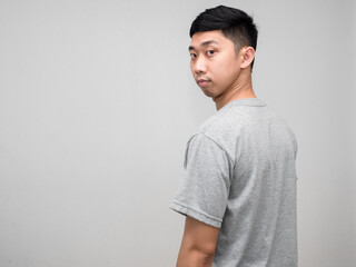 Asian man grey shirt worried face turn around to looking at you isolated