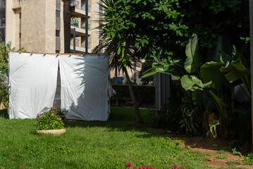 Jewish festival of Sukkot in Israel. Traditional sukkah with handmade decorations near the building on the street. 