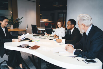 Group of diverse colleagues sharing ideas of project at Manager table in office
