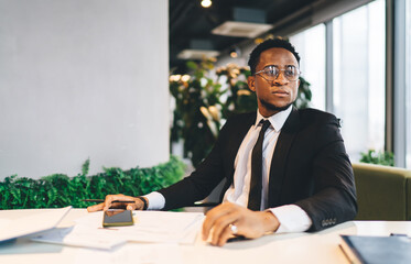 Black businessman with cellphone in office