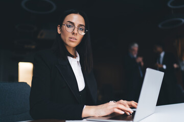 Serious businesswoman working on laptop in office