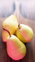 Three Whole Pears Paced On A Oak Desk. Healthy Farm Food. Backside Light. Selective Focus. View Above. Natural Oak Desk Background.