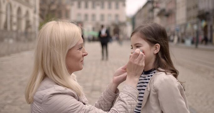 Ukrainian mother drawing a flag on daughter's face