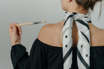 elegant woman holding a spotted painting brush on white background. High quality photo