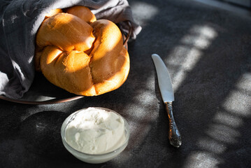 Challah Shabbat braided bread with silver knife and cottage cheese. Traditional Meal for Jewish cuisine Friday or Saturday dinner. 
