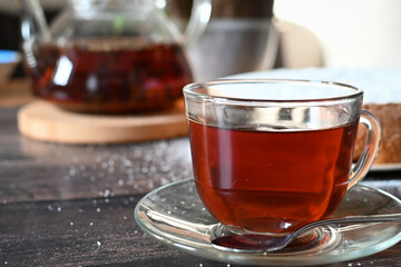 A Cup of freshly brewed black tea,escaping steam,warm soft light, darker background.