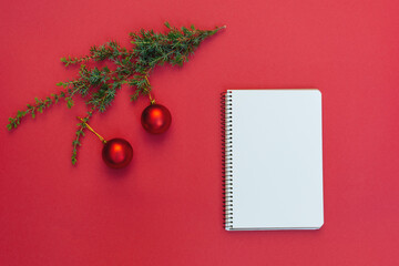 Soft Selective focus on Open blank spiral notebook near Christmas tree branch with decorations on...