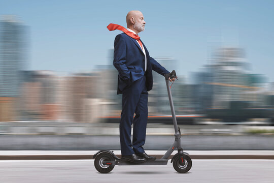 Corporate businessman riding a scooter