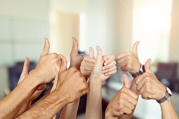 Hands of persons with thumbs up sign on background