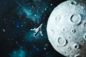 The plane flies near the moon, starry background.