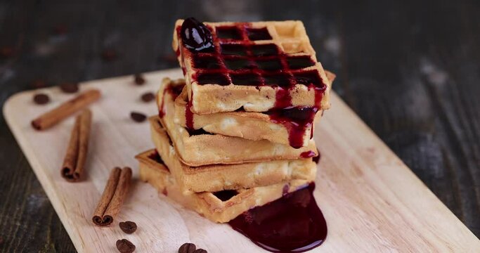 pour cherry jam on a soft waffle , a dessert of waffles with sweet cherry flavor and jam
