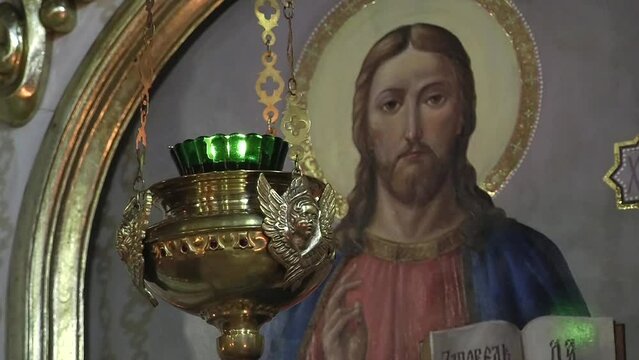 The church lamp hangs against the background of the icon of Jesus Christ in the Ukrainian Church	
