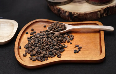 Chocolate pellets with wooden spoon on wooden plate and texture. confectionery raw materials.